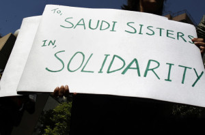 A human rights activist holds a banner during a protest against a Saudi court verdict for a rape victim in Mumbai